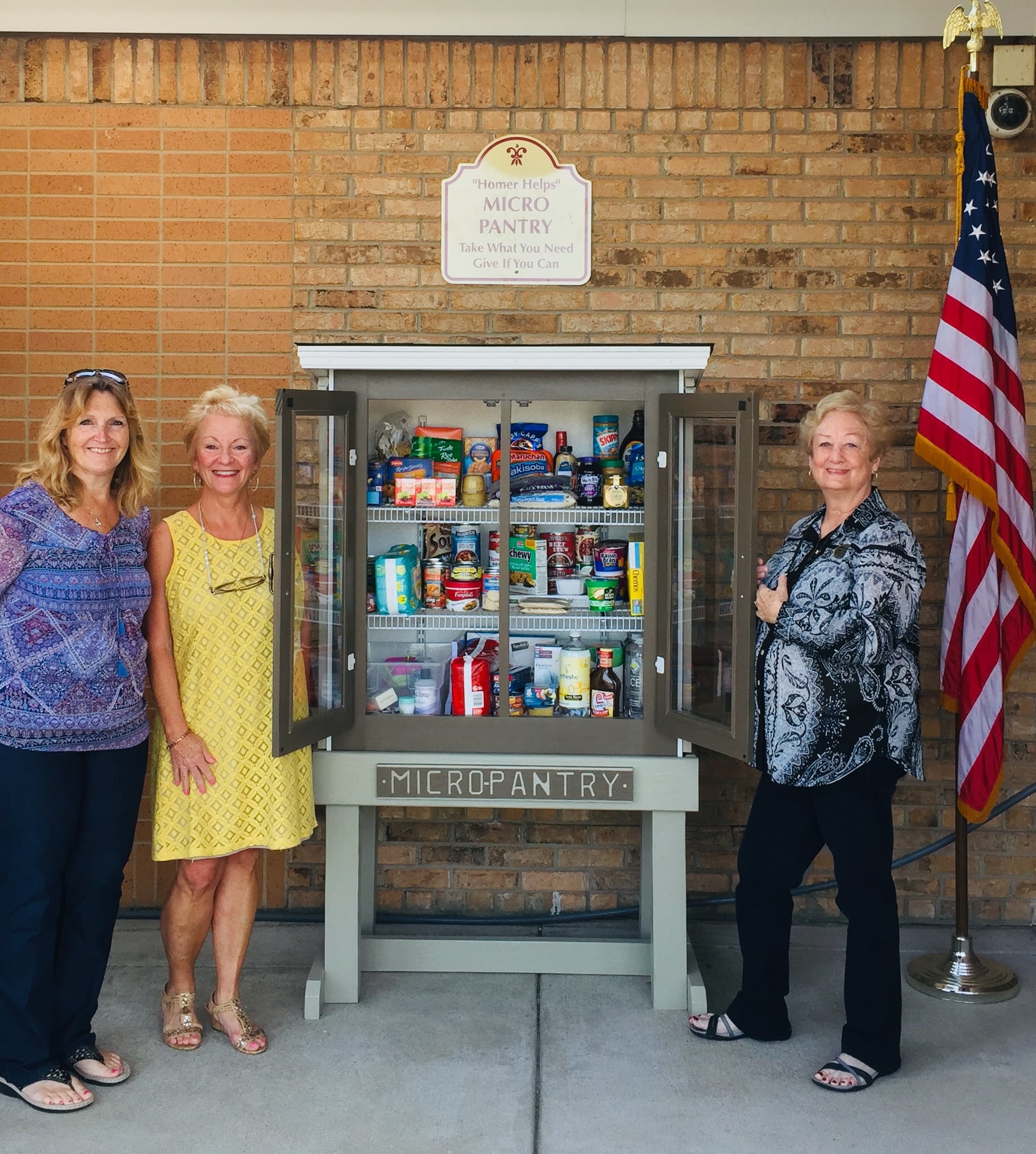 Homer Library administrators and board members around the Micro Pantry cabinet