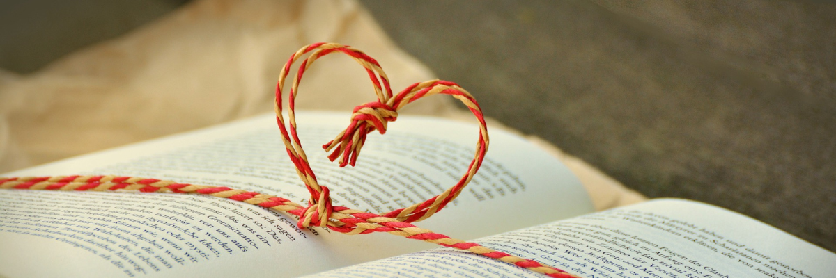 Open book with string tied in heart shape