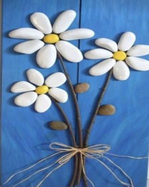 3 daisy like flowers made with smooth stones. Stems are tied together with twine. 