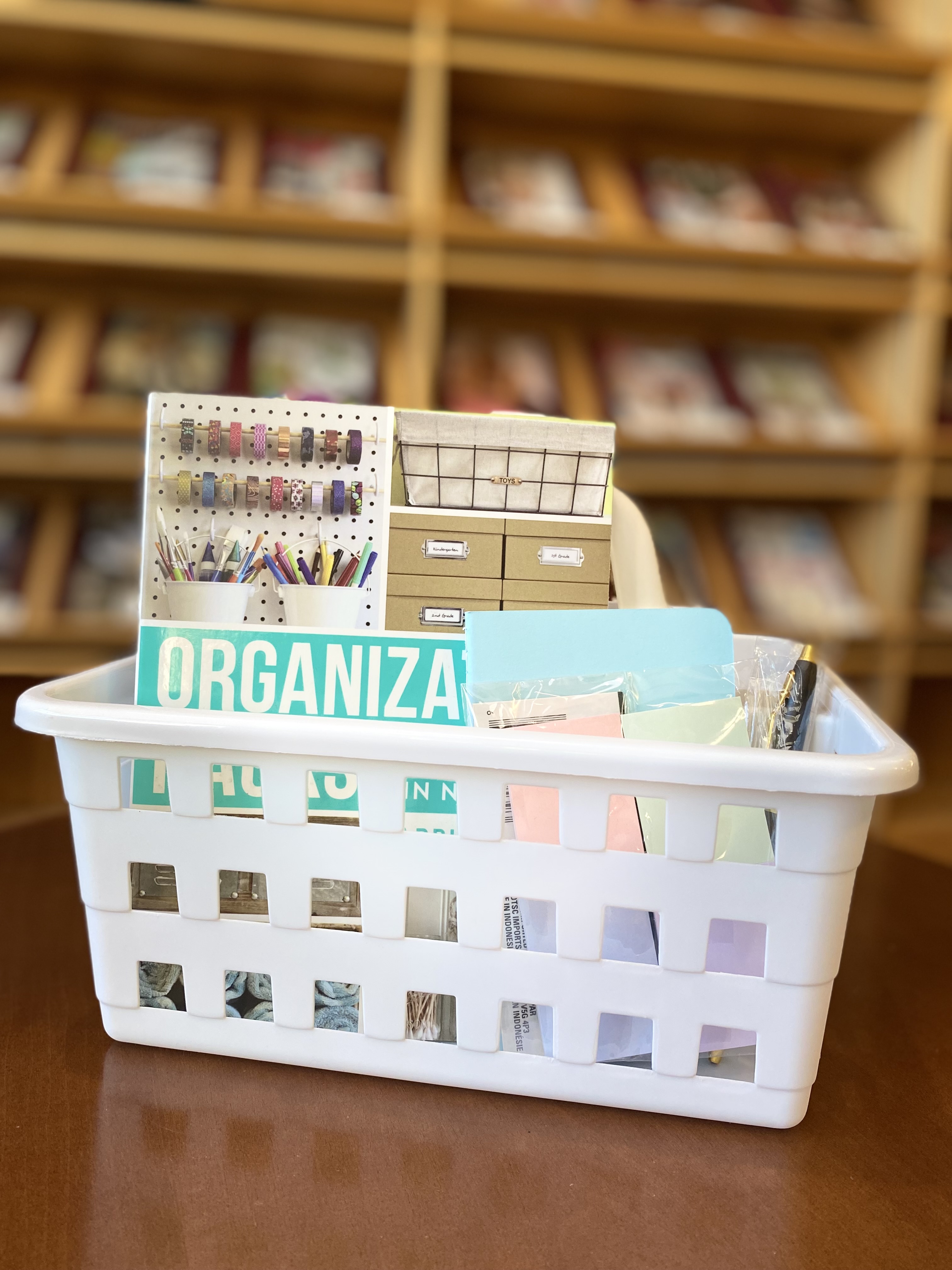 Organization hacks book, white basket, notepads, and a pen