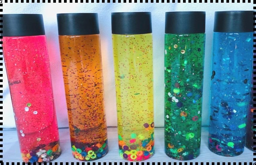 5 water bottles filled with colored water and sparkles.