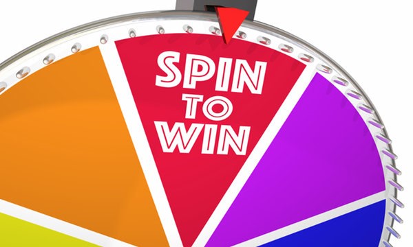 Multicolored prize wheel with words "Spin to Win" in white letters.