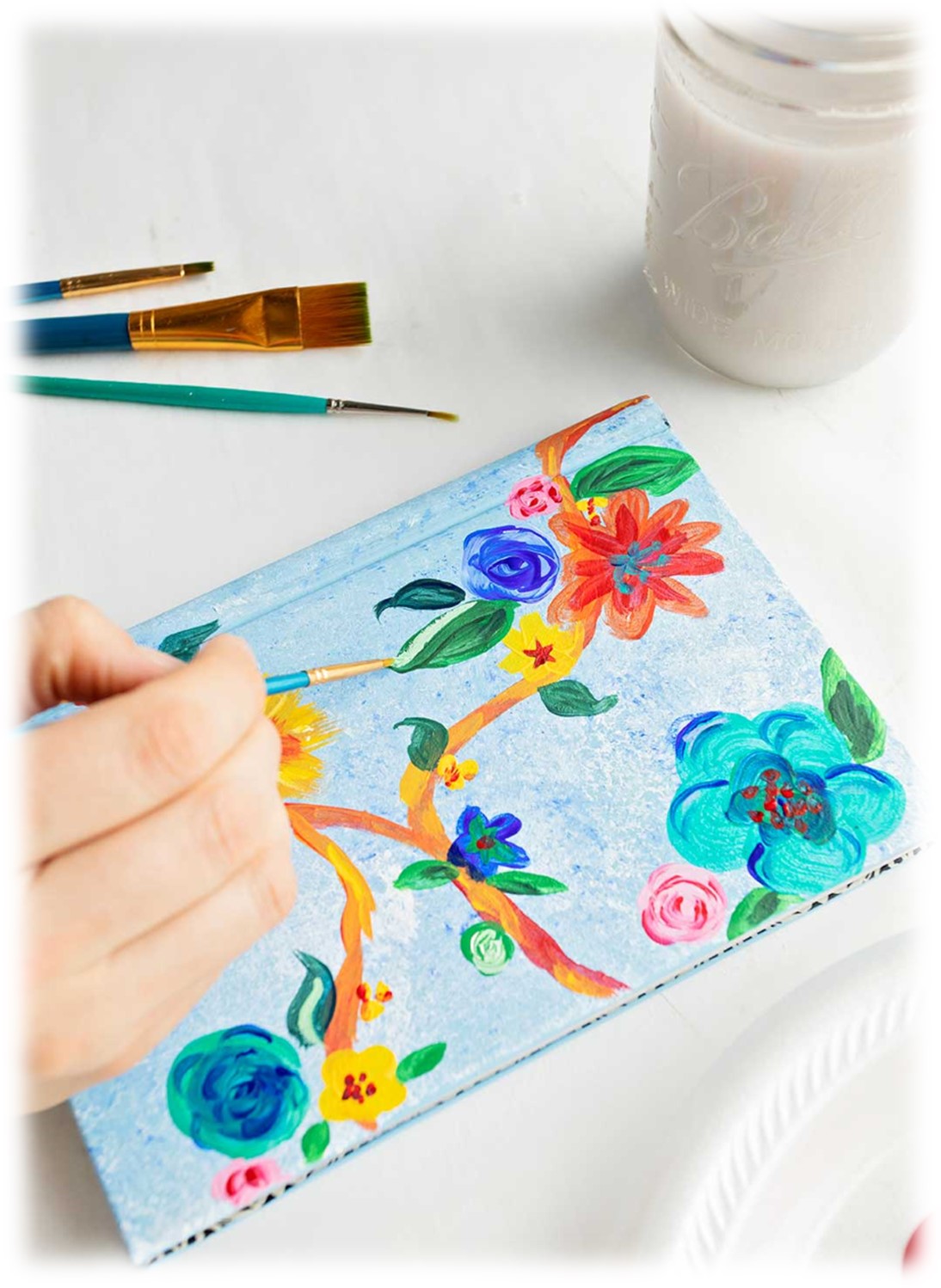 Book being painted with flowers.