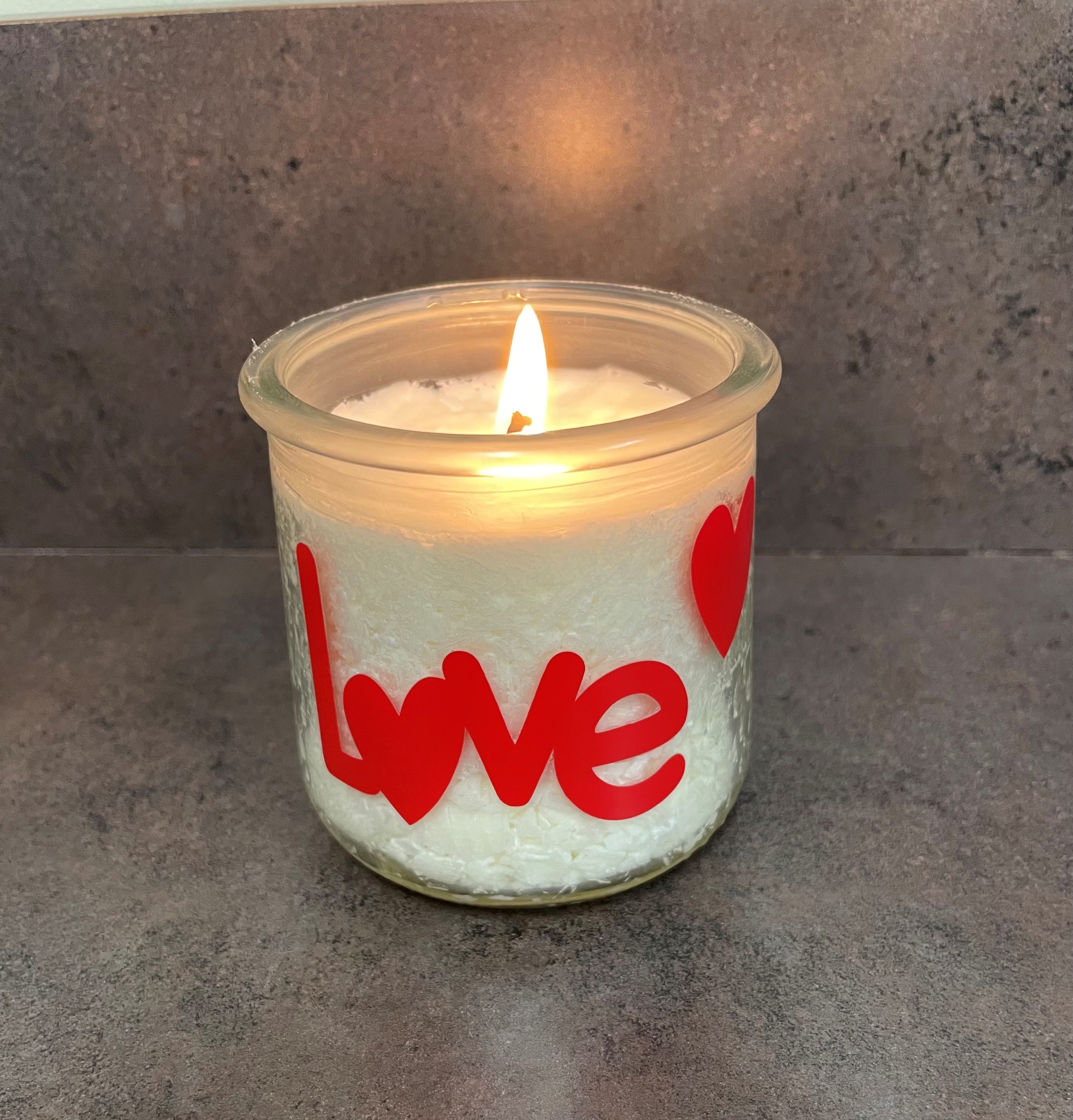 White candle "love" written in red 