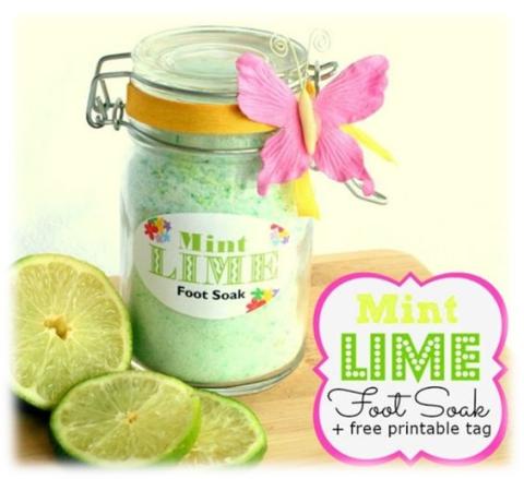 Mason jar with mint lime green foot soak powder. Pink butterfly on jar and sliced limes next to jar. 