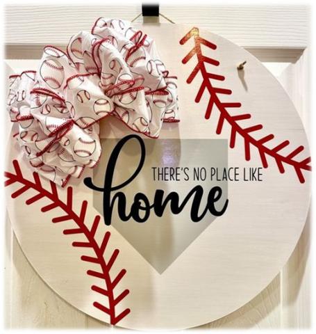 Wooden white circle decorated as a baseball with there's no place like home and a baseball bow.
