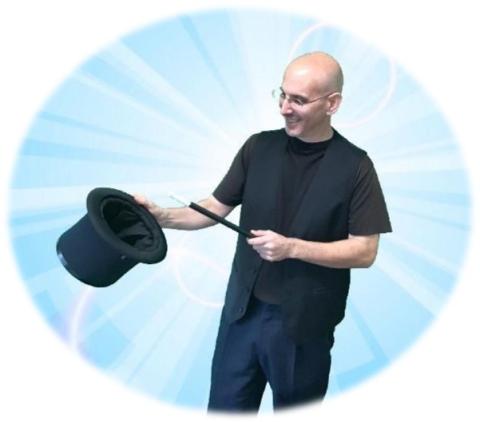 Magician dressed in black with wand pointing at hat.