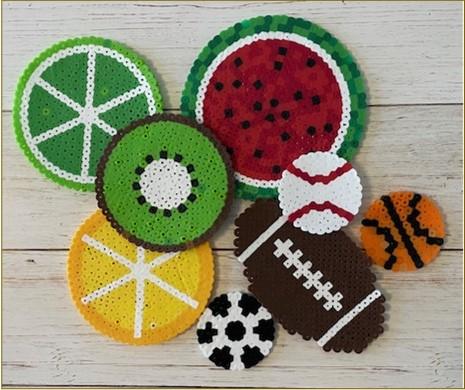 Perler beads shaped into fruit coasters and sport balls.