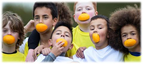 Five children with oranges in their mouths.