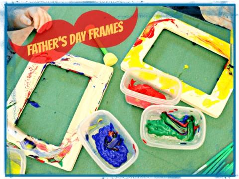 Two wooden frames partially painted in red, blue, and yellow. Blue and green paint in containers, Father's Day Frames written in a red mustache. 
