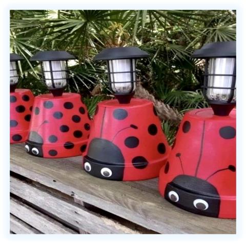 Clay pots painted to look like ladybugs with a solar light in the center. 