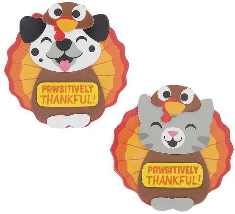 Dalmation dog (white with black dots and ears) and a gray kitty dressed as turkeys with a sign that says "Pawsitively Thankful!".