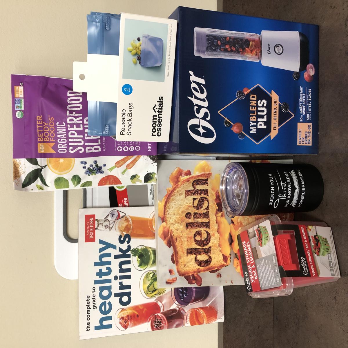 Blender, two cookbooks, a cup, cutting board and protein powder. 