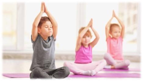 Three kids sitting on floor with legs crossed and arms above heads with hands clasped. 