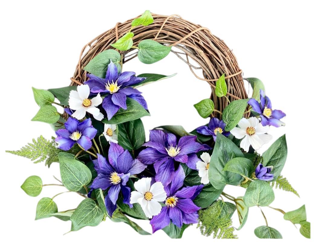 Wooden wreath with purple and white Clematis flowers and green leaves.