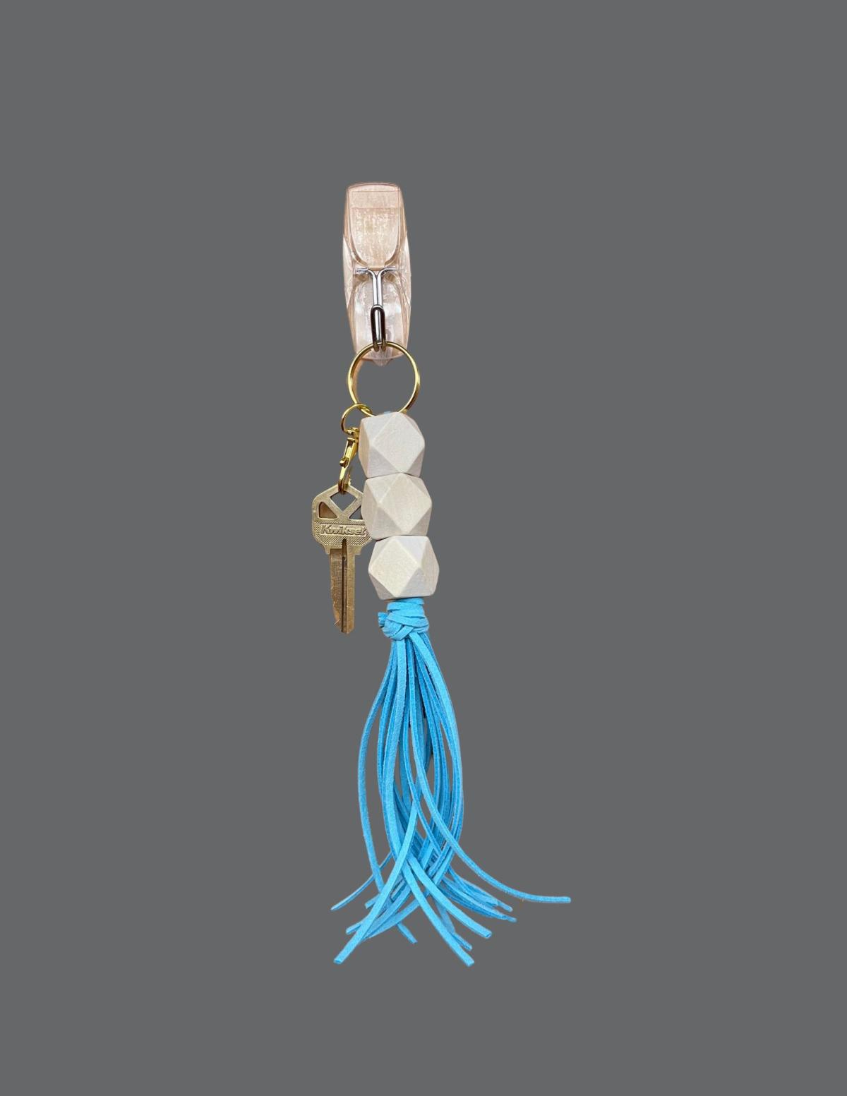 Picture of a key ring with a blue tassel. 