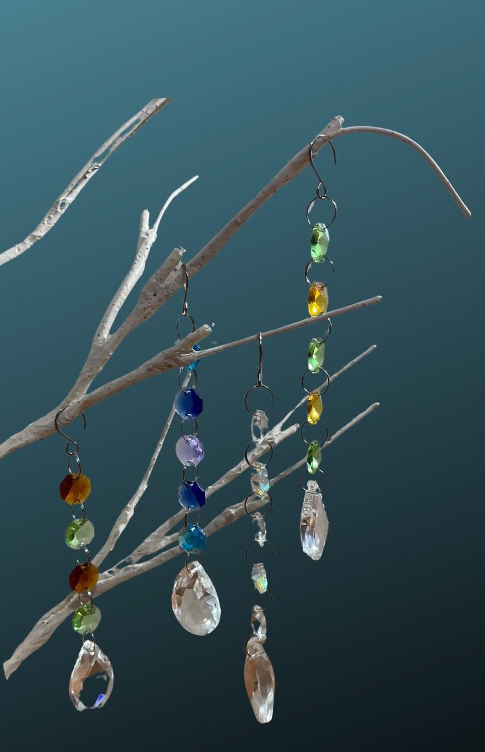 Picture of crystal suncatchers hanging from a tree branch. 