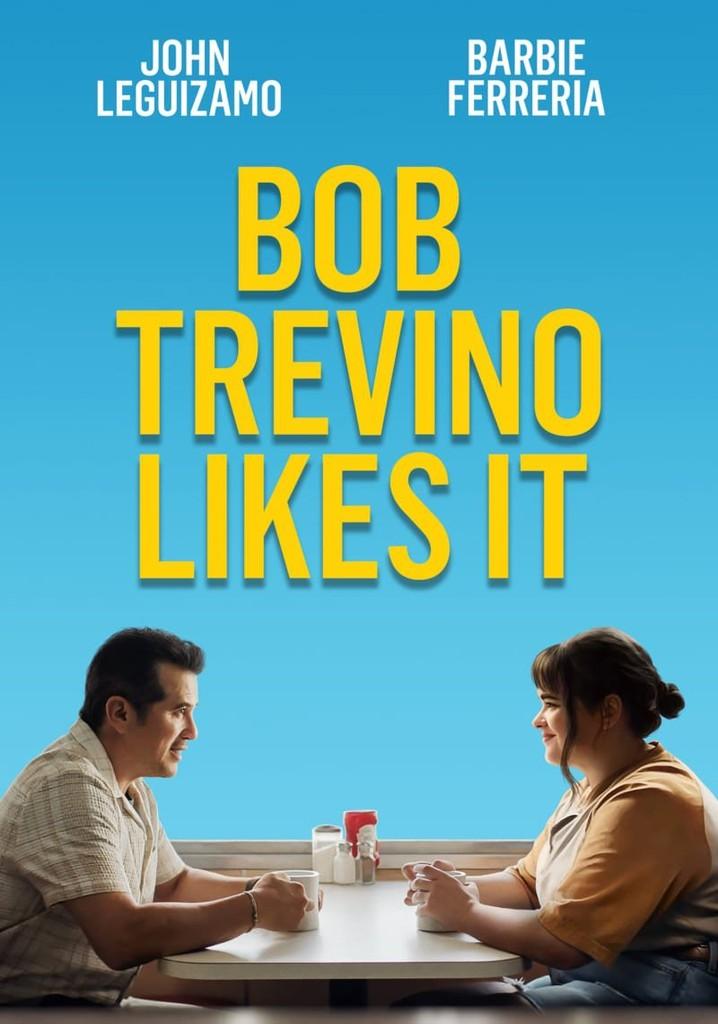 A man and a teenage girl sitting at a table smiling at each other. 