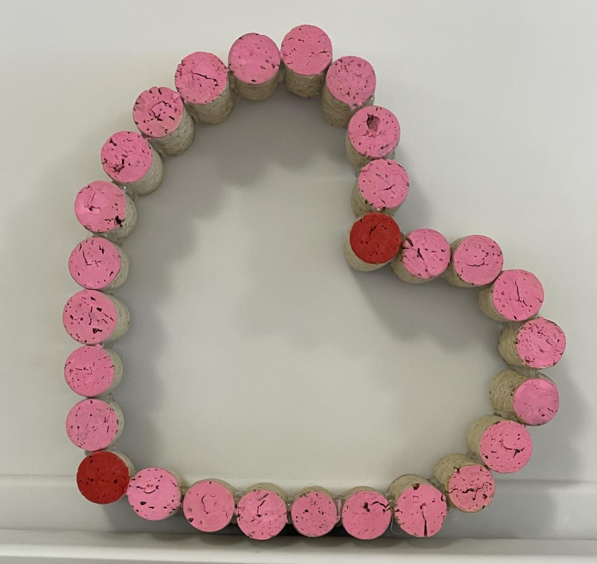 A heart made out of pink corks. 
